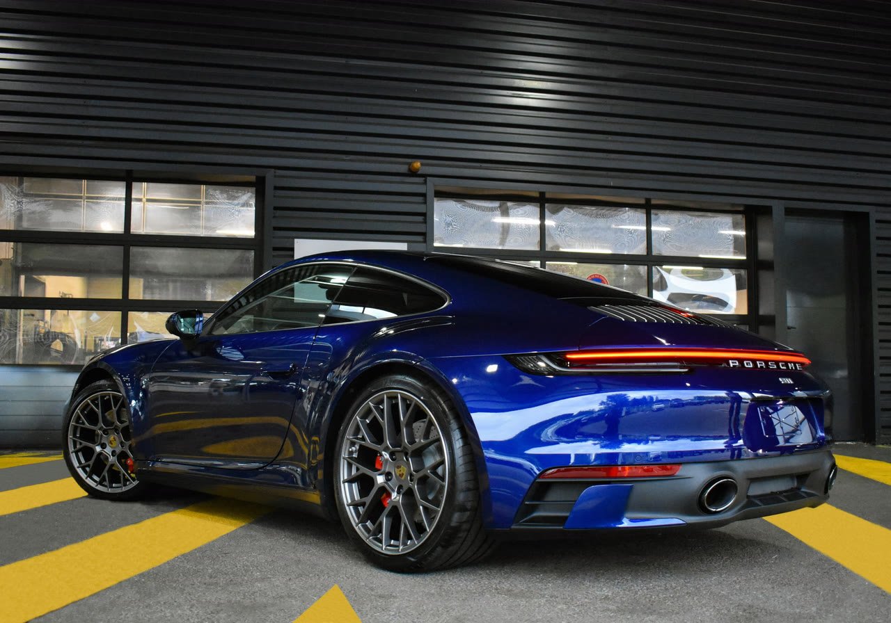 Porsche 911 Carrera azul aparcado a la salida del taller, listo para la entrega